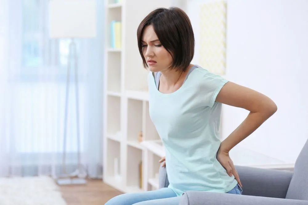 sitting woman holding her lower back